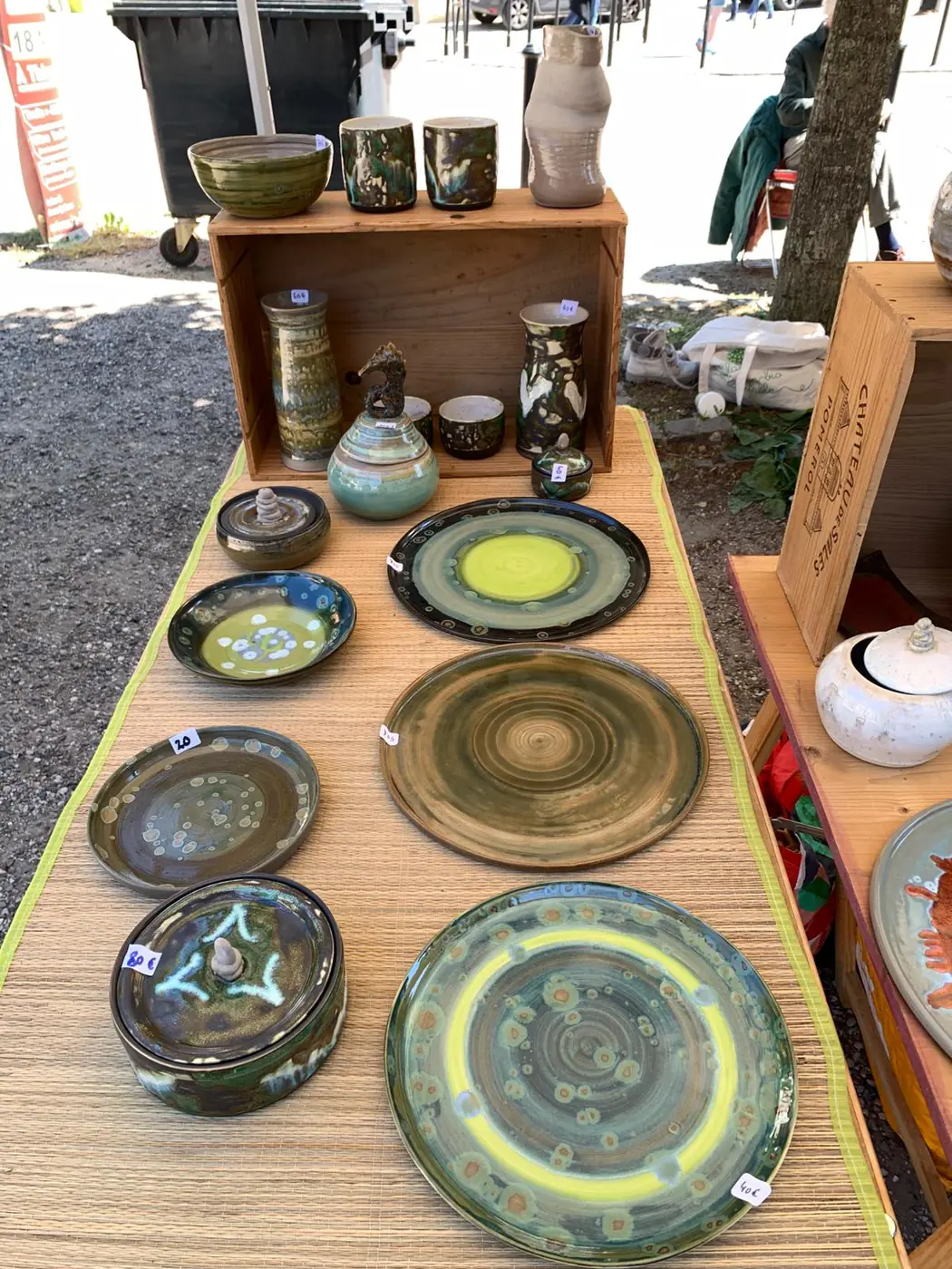 Assiettes et plats émaillés verts et bruns présentés sur une table