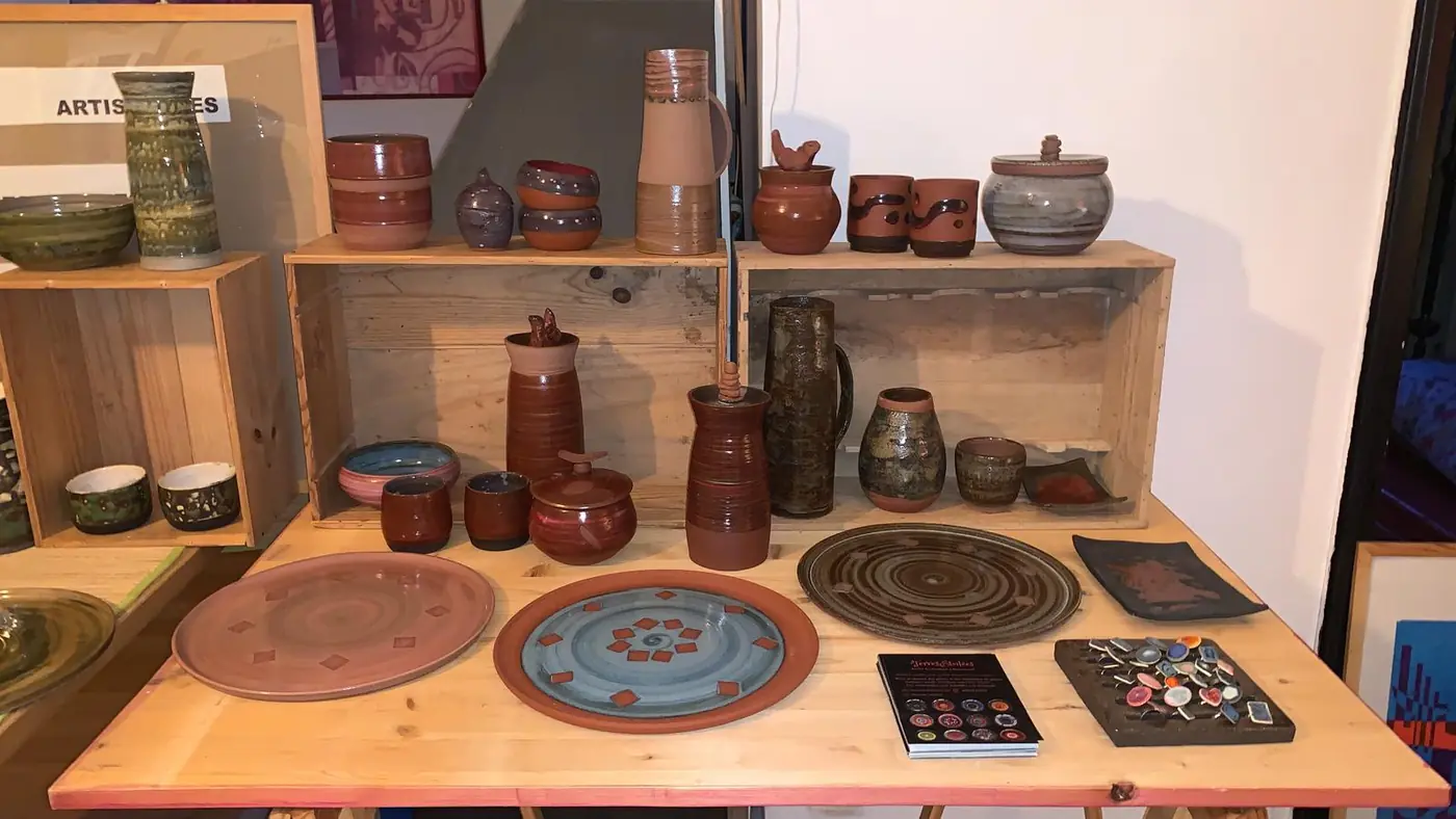 Étagères en bois garnies de pots, pichets et assiettes